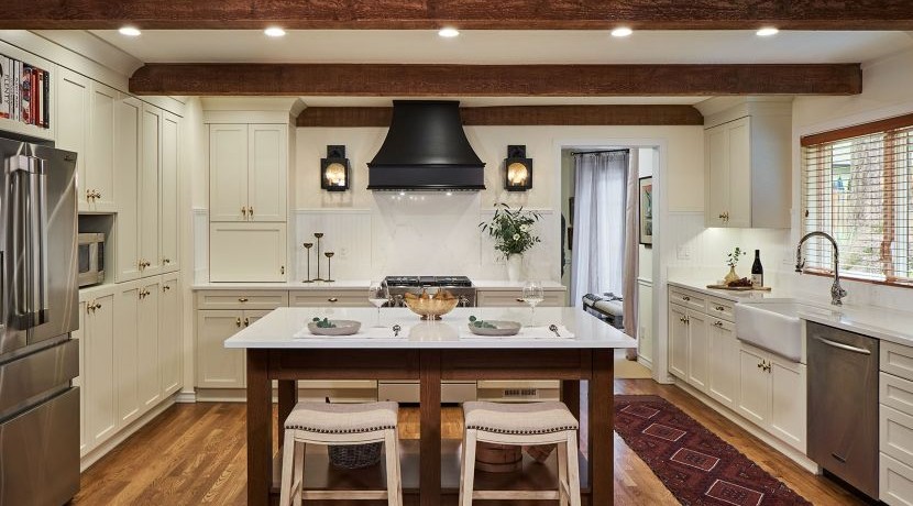 A reimagined kitchen with a changed layout, exposed beams and a central island table