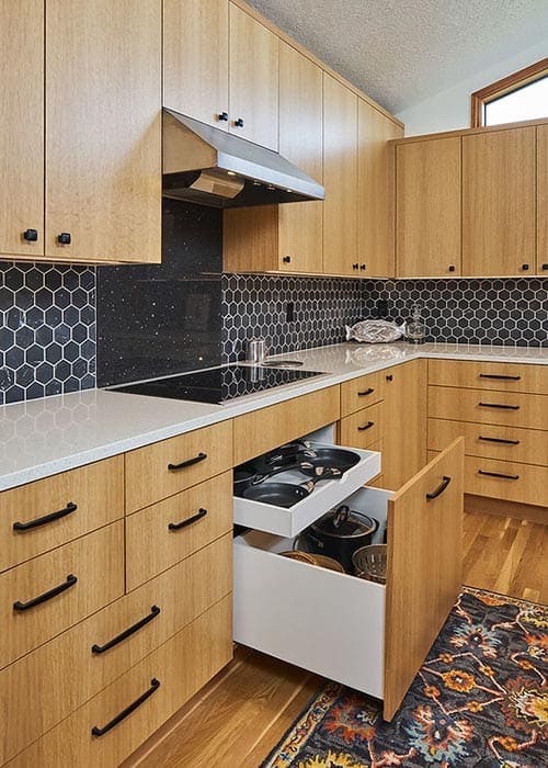 Custom wood cabinetry with under stove pot and pan storage