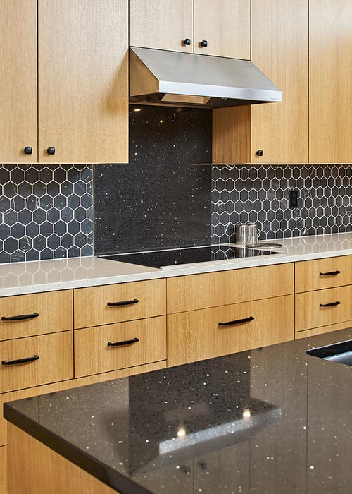 Modern kitchen with contrasting countertops and hexagonal tile backsplash in Portland