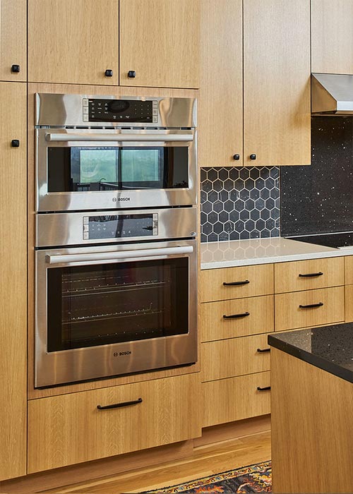 Open concept modern kitchen with bar and custom wood cabinets