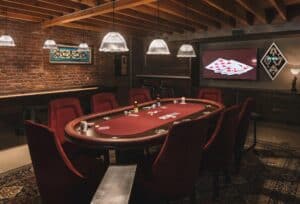 Speakeasy-style man cave with poker table and retro pendant lighting.