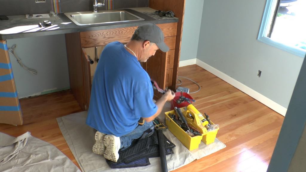 A Neil Kelly handyman repairs a sink