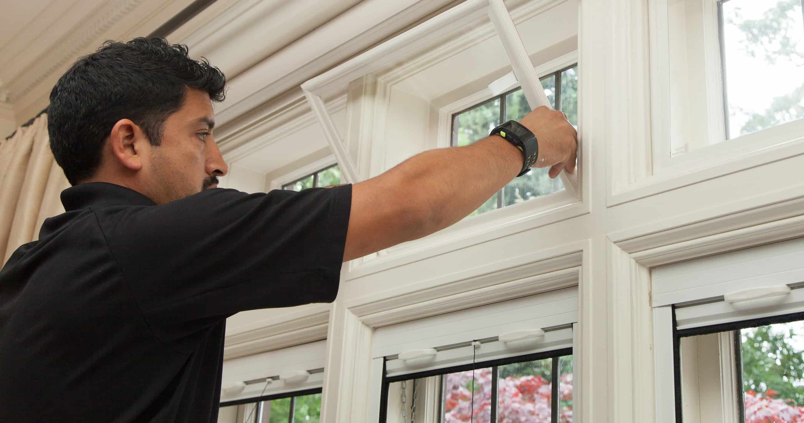 Neil Kelly puts the finishing touches on a window installation