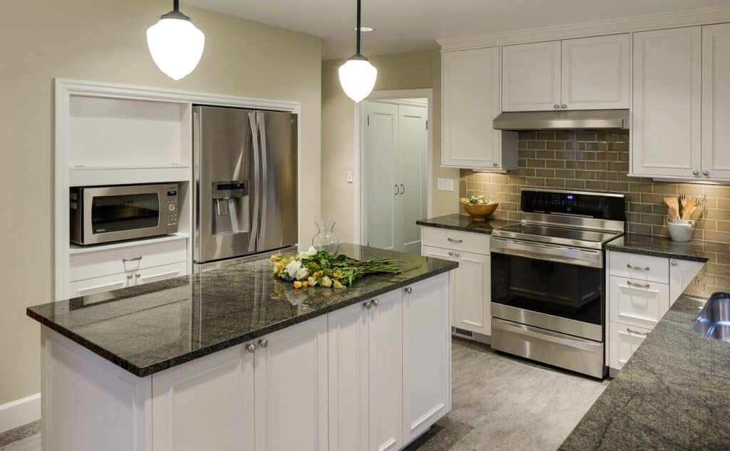 Appliances set into the wall underneath an adjacent staircase