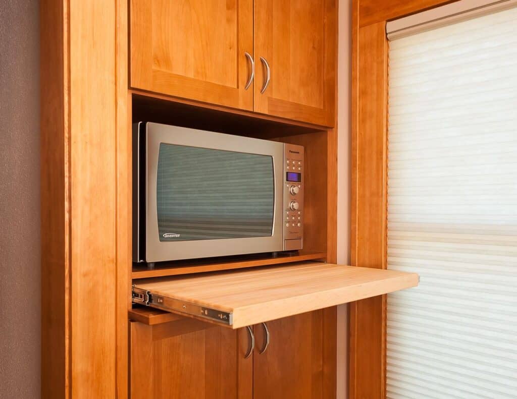 A pop out countertop creates a tiny prep area in front of the microwave