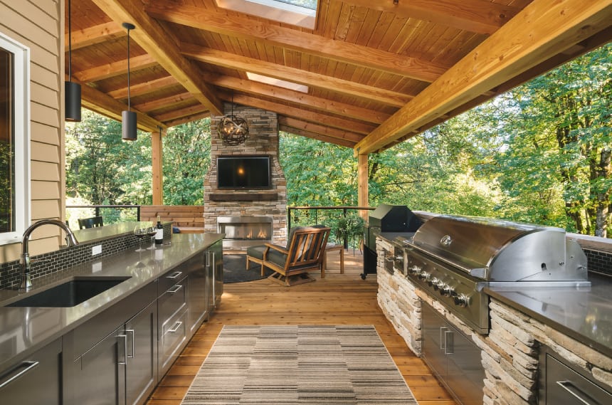 Wood outdoor kitchen with appliances and seating area.