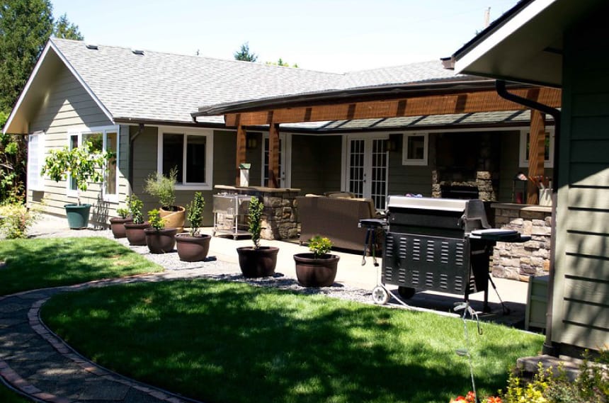 Outdoor kitchen with backyard space and lawn area.