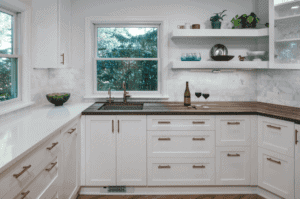 Kitchen with white cabinets and drawers with black pull handles.