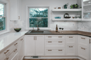 Kitchen with white cabinets and drawers with black pull handles.