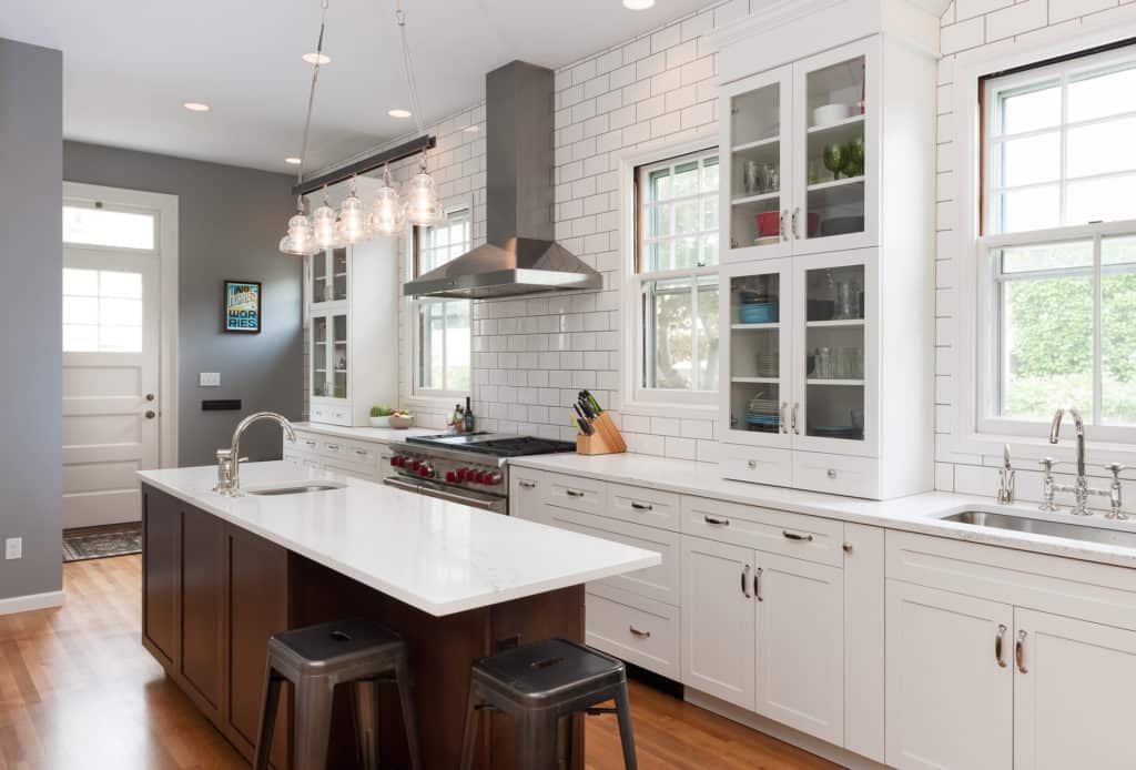 Statuario polished quartz countertop, industrial glass lighting fixtures, nickel Rohl faucets, stainless steel Sub-Zero, Wolf and Cove Asko appliances.