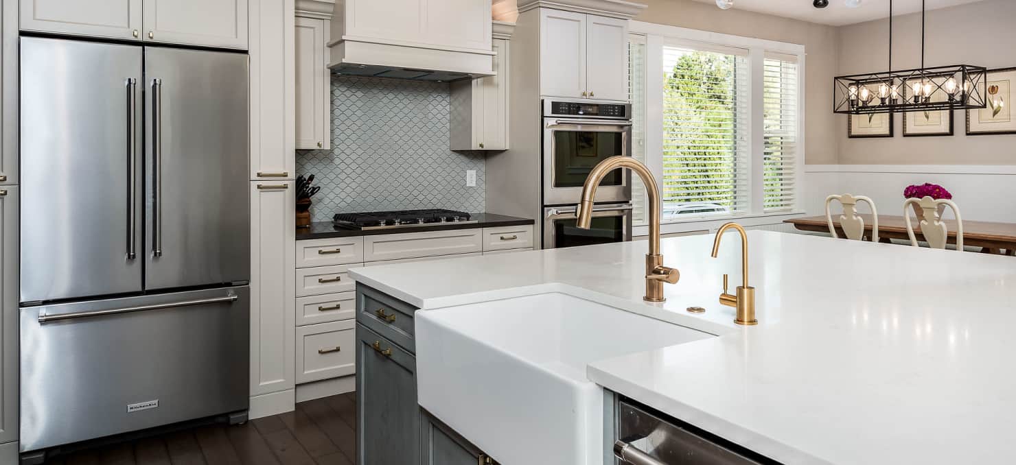 Statuario polished quartz countertop, industrial glass lighting fixtures, nickel Rohl faucets, stainless steel Sub-Zero, Wolf and Cove Asko appliances.