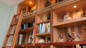 wood bookcase featuring books and sculptural items..