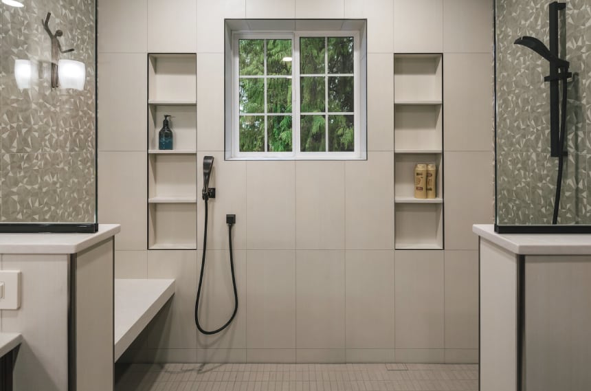 Bathroom shower with a handheld shower head and shower bench.