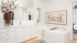 white marble bathroom with bathtub and matching sink.