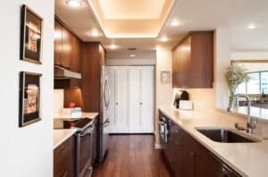 Gallery kitchen with an electric range on the left and a countertop and sink on the right.