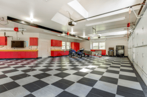 Converted garage with checkered flooring, tool storage along the back wall, and two motorcycles.