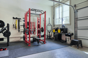 Workout squat and bench rack in a garage converted into a home gym.
