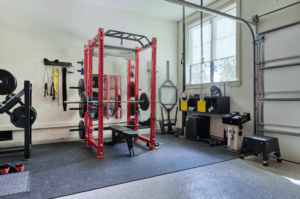 Workout squat and bench rack in a garage converted into a home gym.