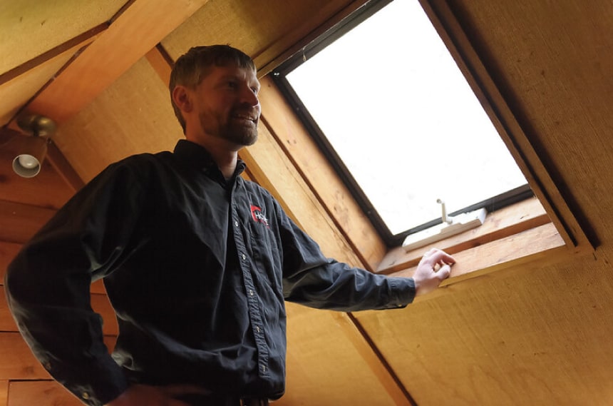 neil kelly employee standing next to window in attic.