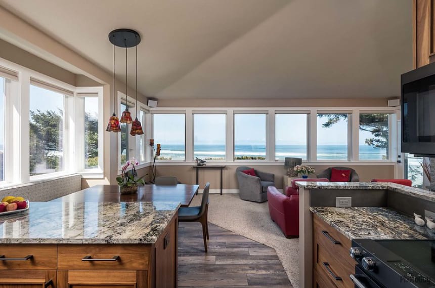 home next to ocean with large windows.