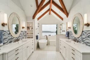 Bathroom with white vanities and light blue tile backsplash painted like waves.