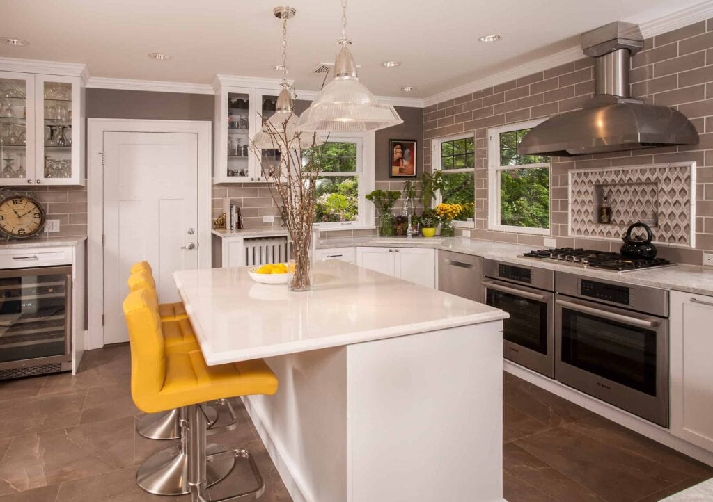 Kitchen with white glass front cabinets and three windows