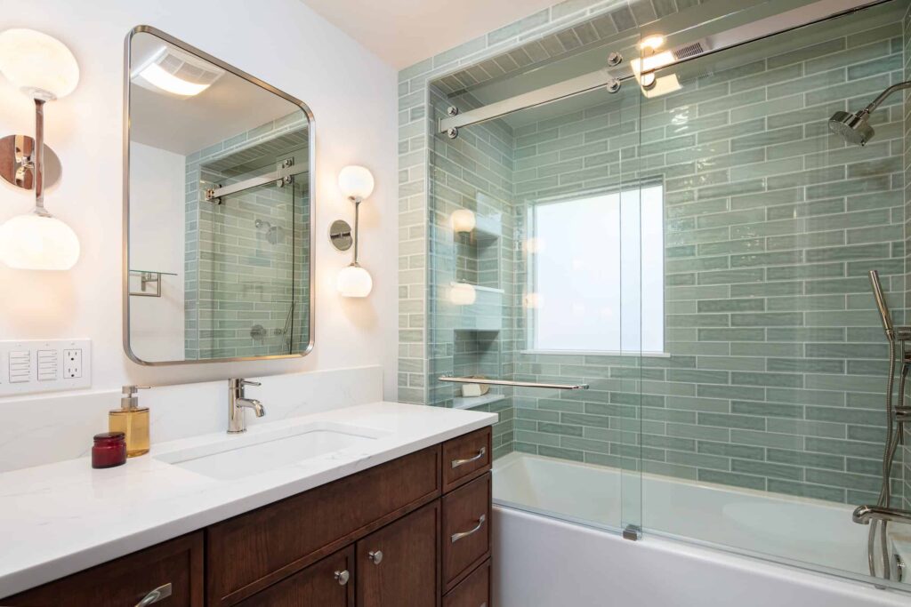 transitional warm green tiled bathroom with shower and tub combo
