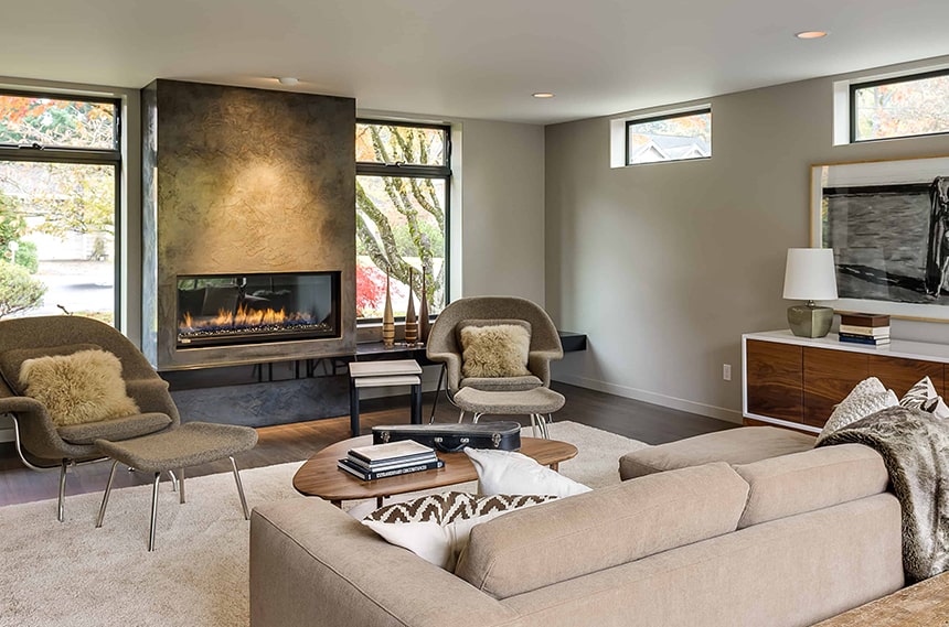 Renovated living room with large gas fireplace with beige furniture