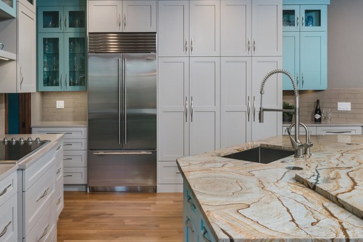 Wall of white cabinets with built-in refrigerator with bottom freezer