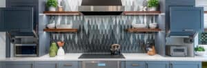 Kichen with blue backsplash, an induction cooktop, and stainless steel air vent.