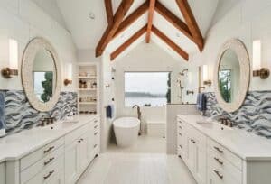 White, double vanity with quartz countertops leading to a bath tub and shower alcove.