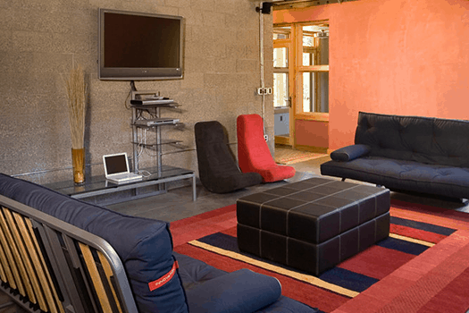 Modern industrial room with exposed cement and entertainment space