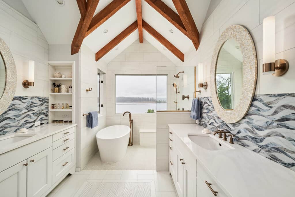 White, double vanity with quartz countertops leading to a bathtub and shower alcove.