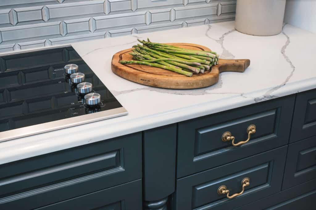 Warm colored hardware adorns dark cabinets.