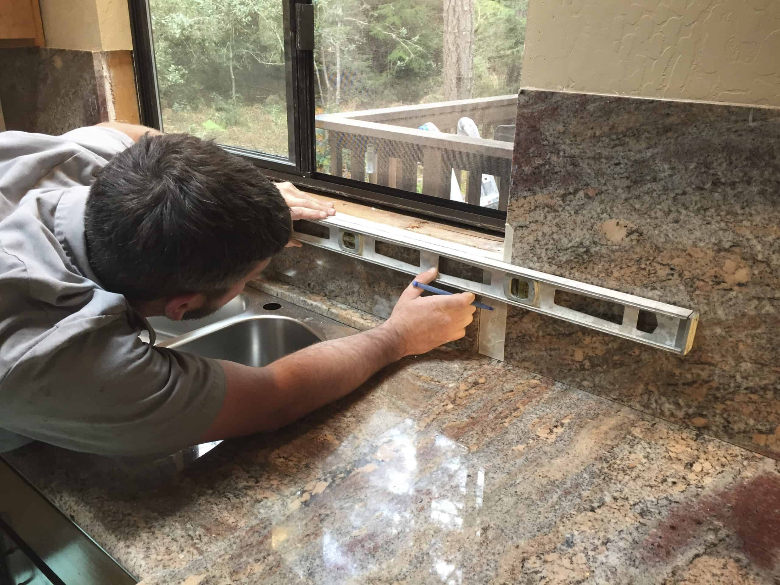 Person installing backsplash and counters