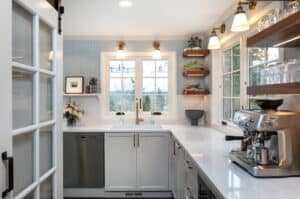 L-shaped kitchen with a granite counter top and wooden floating shelves.