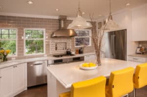 Modern kitchen with subway tile walls, a quartz countertop island, stainless steel appliances, and white cabinetry.