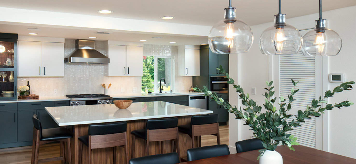 Seattle single wall kitchen with large center island with four wooden bar chairs.