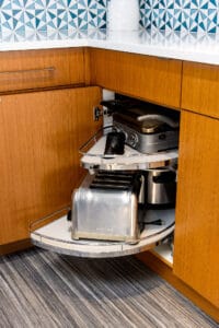 Lower corner cabinet pull out shelves with kitchen appliances on top.