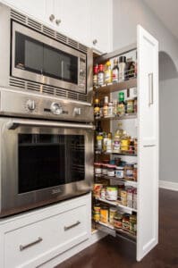 Vertical kitchen storage pull out racks with spices.