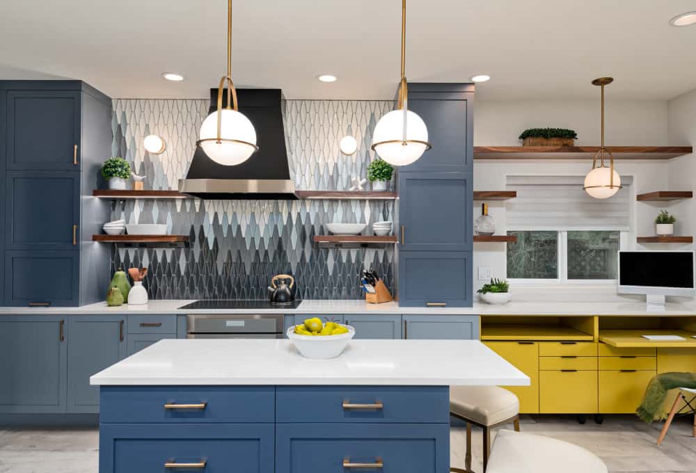 Modern kitchen remodeling project with blue wooden cabinets, a center island, white countertops, and stainless steel appliances.