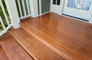 Wooden stairs that lead to a white front door.