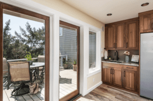 Dark wood kitchen next to large windows and door to the outside.