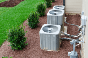 multiple air conditioning units next to home exterior.