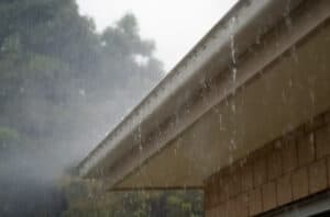 rain falling off of a roof and gutter.