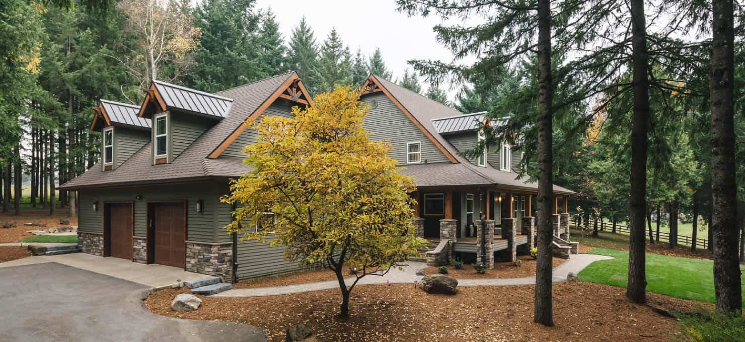 a neighborhood home with a fall tree in the front yard.