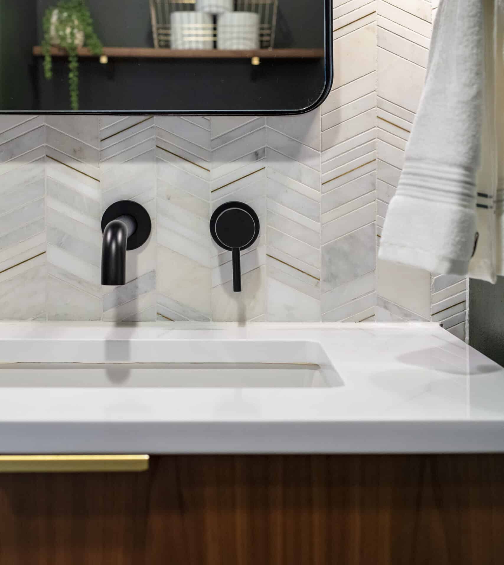 Powder bath vanity with black wall-mounted faucet.