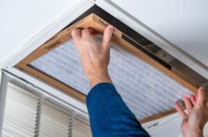 man replacing hvac filter.