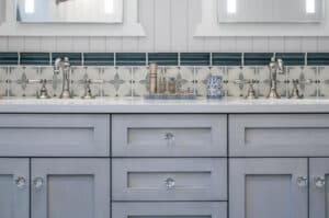Double-sink vanity in a bathroom with chrome facets and subway tile on the walls.