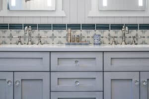 Double-sink vanity in a bathroom with chrome facets and subway tile on the walls. 